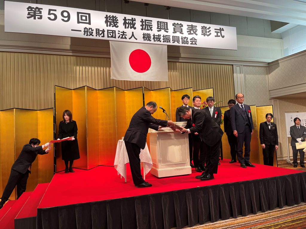 機械振興賞 釜 和明会長から
受賞の盾を受け取る内村センター長