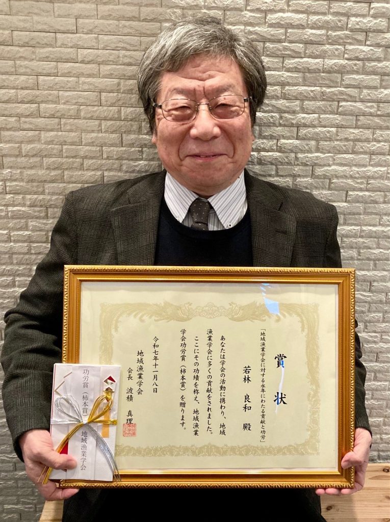 賞状と副賞を手にする若林良和特命教授